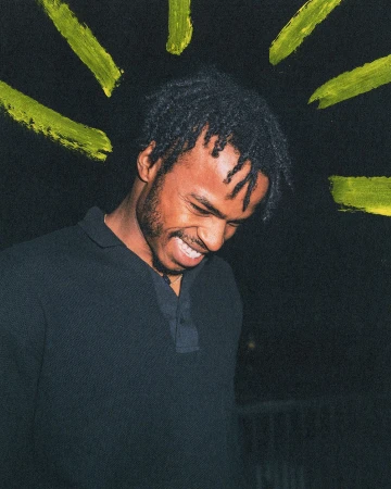 Portrait of a black man smiling in a dark polo shirt against a black background with painted yellow marks overhead by Arturo Torres