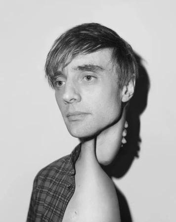 Monochrome portrait of a man with a flannel shirt and a surreal neck, against a neutral background, creating a striking visual.