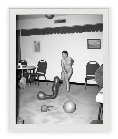 Black and white framed photographic print of a nude figure in a domestic interior with distorted objects