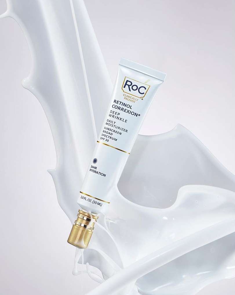 RoC Retinol Correxion Deep Wrinkle Daily Moisturizer product shot. White tube with gold cap on cream-colored backdrop. Beauty, skincare.