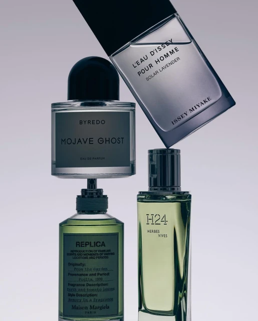 Four perfume bottles from different brands including Byredo Mojave Ghost and Issey Miyake Eau D'Issey arranged in a stack formation.