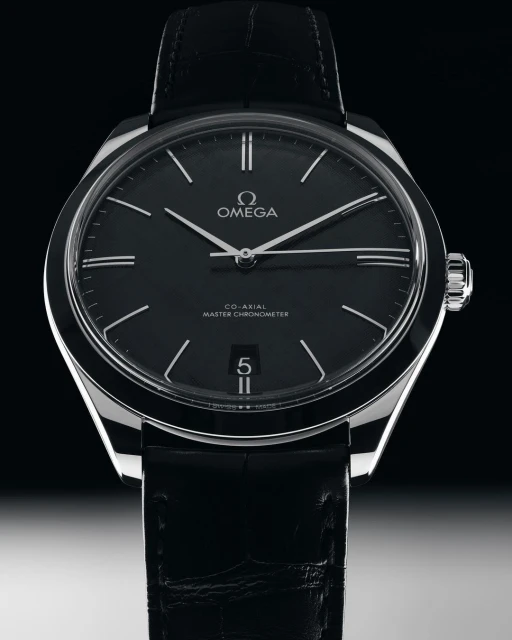 Omega wristwatch close-up against dark background. Stylish black leather band and silver case. Black dial with silver hands.