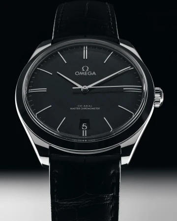 Omega wristwatch close-up against dark background. Stylish black leather band and silver case. Black dial with silver hands.