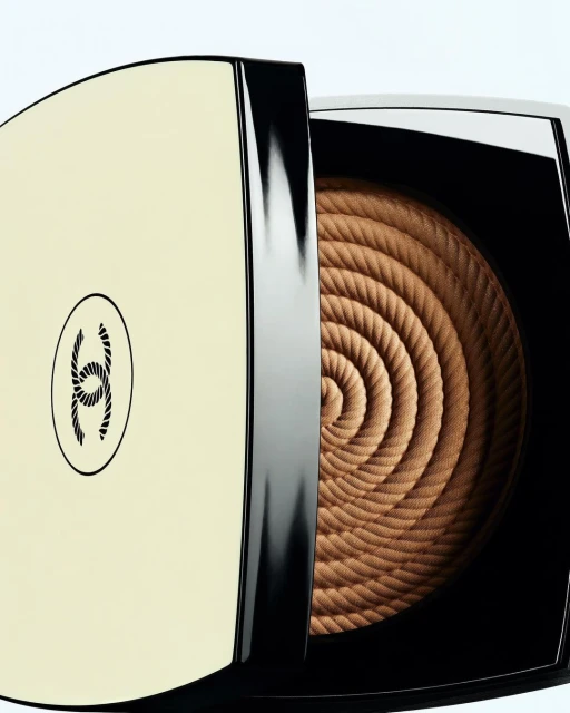 Close-up of bronzer makeup with spiral rope pattern in a square compact case featuring the Chanel logo on a white background.