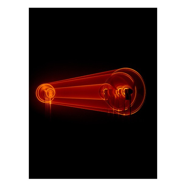 Abstract image featuring a set of concentric, glowing orange circles connected by trails of light against a stark black background.