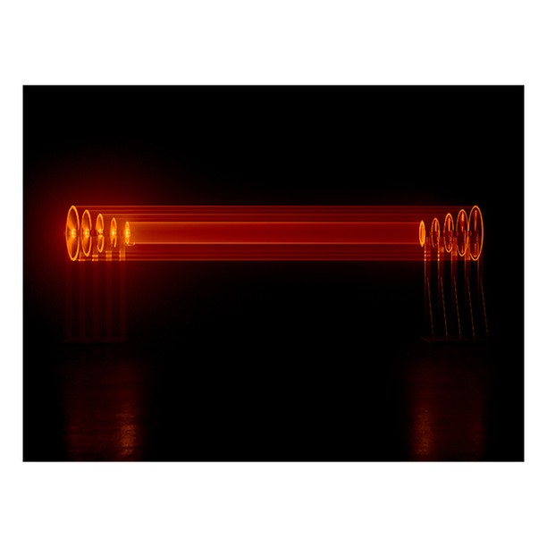 Abstract long exposure photography showing a horizontal line of orange light with a dark background and a reflective surface below.