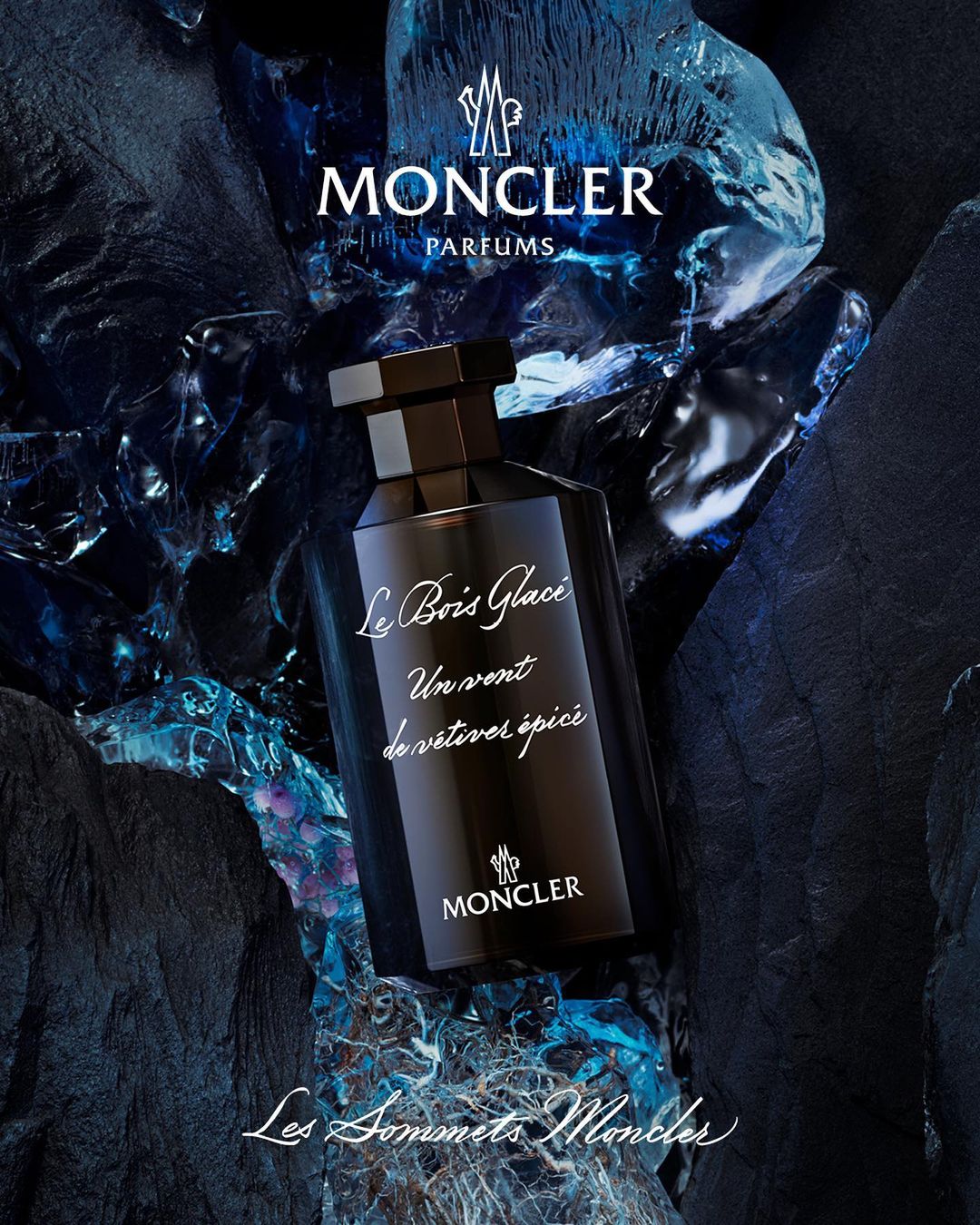 Moncler Le Bois Glace fragrance bottle displayed against a textured stone backdrop, brand logo in view, dark and cool color palette.