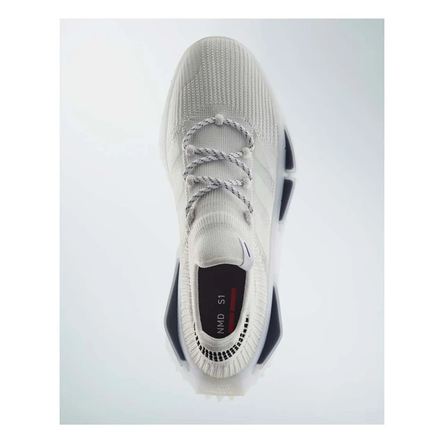 Studio shot of an Adidas NMD S1 sneaker featuring a sock-like construction, rope laces, and a white color scheme against a white background.