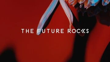 Close-up studio shot of an orange and white chrysanthemum against a red background with white text overlay: "THE FUTURE ROCKS."