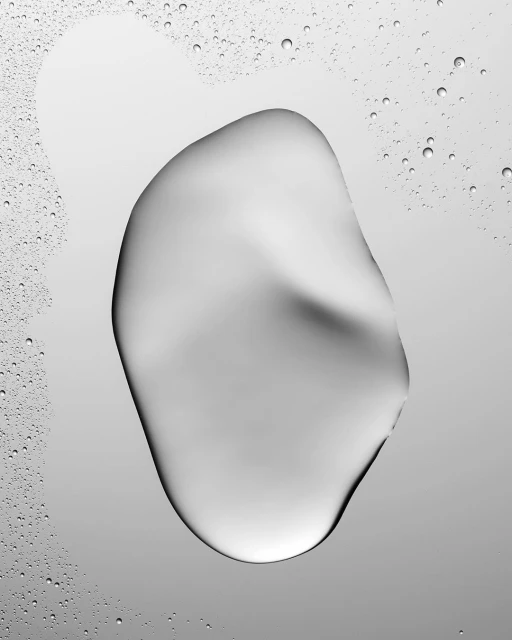 Abstract close-up of a clear liquid drop on a gradient gray surface with smaller droplets in the background, creating a clean, minimal image.