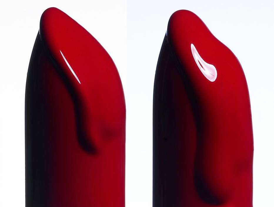 Close-up of two red lipstick bullets with a glossy, smooth texture against a bright white background, showcasing makeup details.