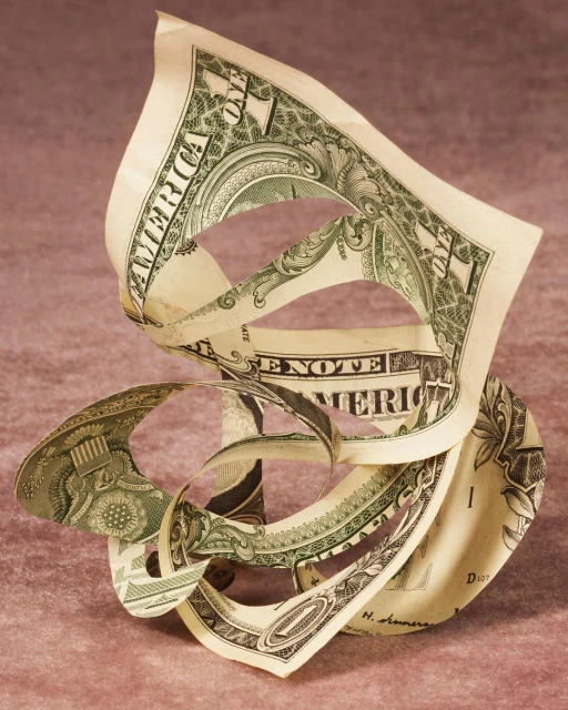 Close-up abstract still life shot of a gently twisted US one dollar bill against a pink textured background in soft studio lighting.