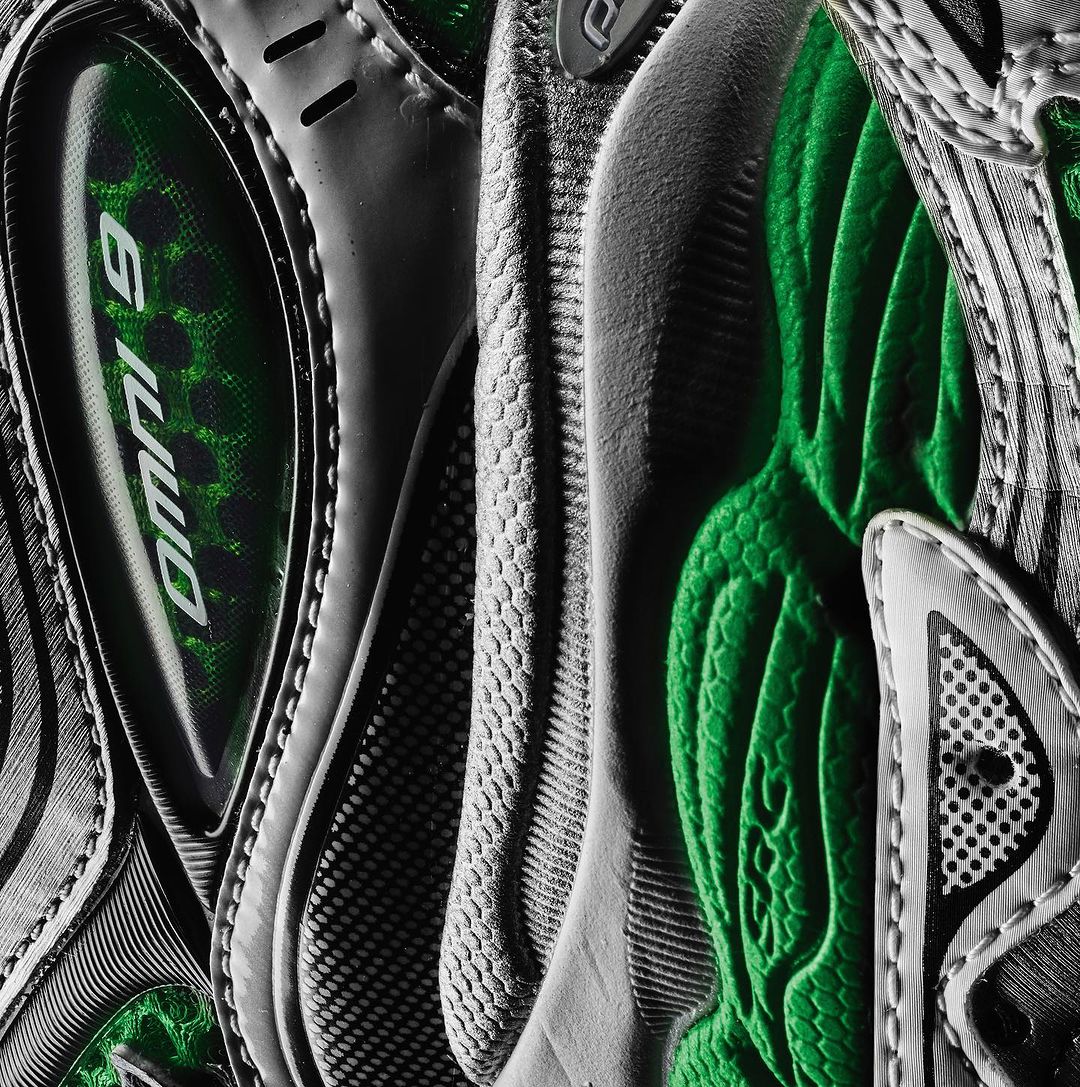 Close-up detail of a grey and green athletic shoe showing the textures, patterns, and construction of the footwear.