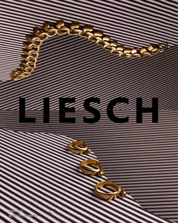 Promotional still life product shot featuring gold jewelry, including a bracelet and rings, displayed on a striped surface.