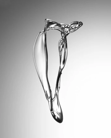 Abstract water splash shape against gray gradient background creating a sense of motion and fluidity in a studio setting.