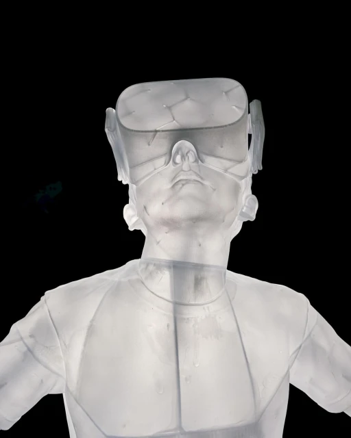 Translucent human bust wears a VR headset against black. The white sculpture is set against a stark, dark backdrop.