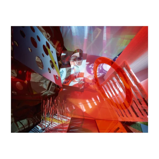 Abstract art featuring red, white, and blue geometric shapes and lines in an interior setting with mixed lighting conditions.