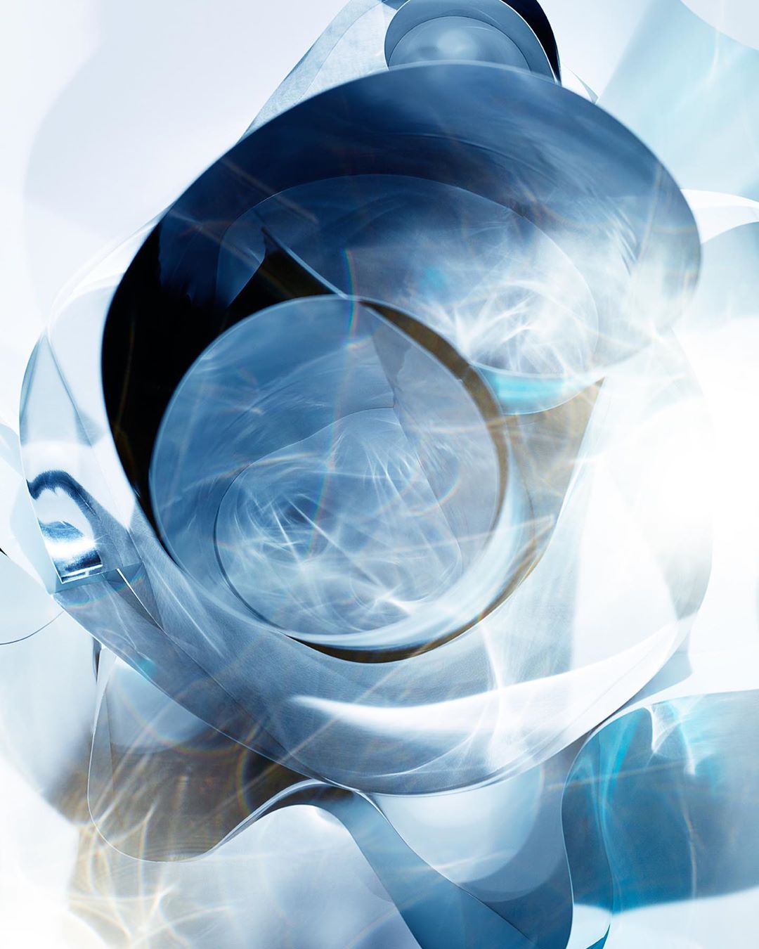 Abstract rendering of curved, translucent shapes in light blue and white, creating a modern, flowing, and visually intriguing composition.
