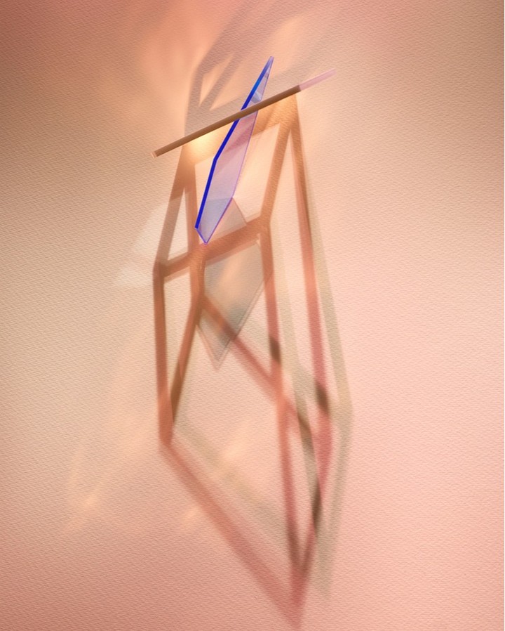 Abstract photography of geometric shapes with sharp shadows cast against a pale pink wall background in vertical composition.
