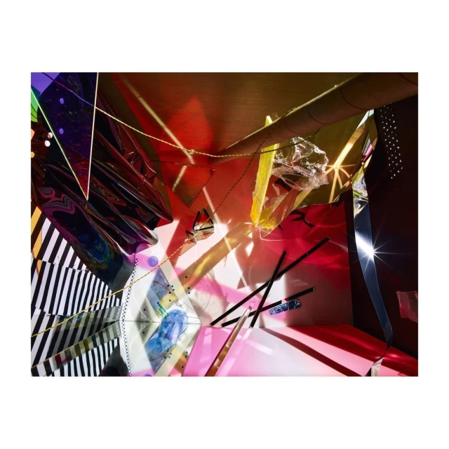 Abstract studio photograph of colorful cellophane, geometric shapes, and linear forms with directed light and dark shadows.