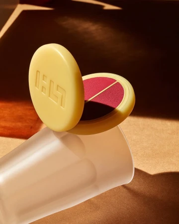 Beige makeup compact with blush on warm brown surface with graphic shadows and frosted glass - beauty and cosmetics product shot.