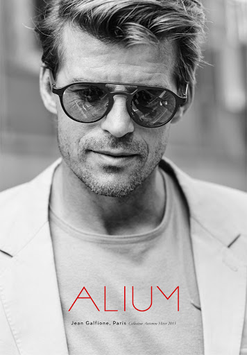 Close-up portrait of a man wearing round sunglasses and a light blazer with make-up artistry by Laure Dansou