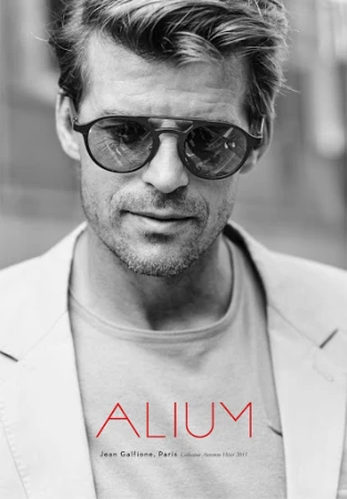Close-up portrait of a man wearing round sunglasses and a light blazer with make-up artistry by Laure Dansou