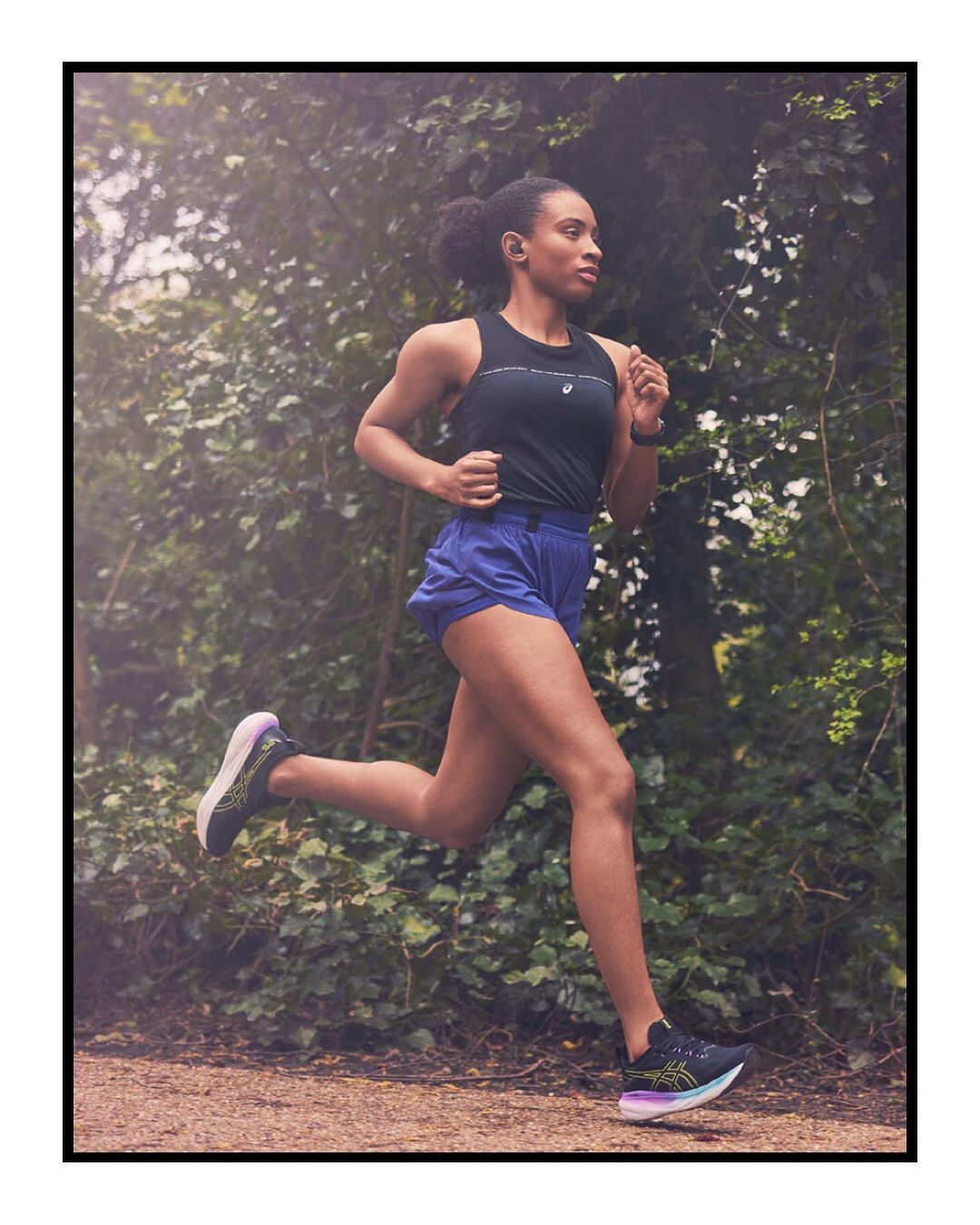 Woman running outdoors wearing athletic gear and running shoes in a wooded environment with natural light, captured in a medium shot.