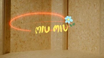 MIU MIU logo with a flower and an orange light trail set against a light wood textured background in a close-up shot.
