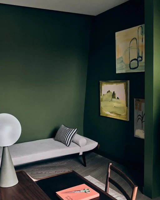 Interior view of a room featuring a daybed with a striped pillow, complemented by artwork and a lamp in a home setting.