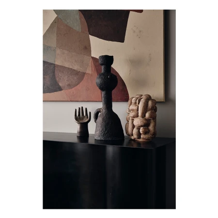 Still life featuring three sculptural vases displayed on a sleek black console table with an abstract artwork in the background, showcasing modern design.
