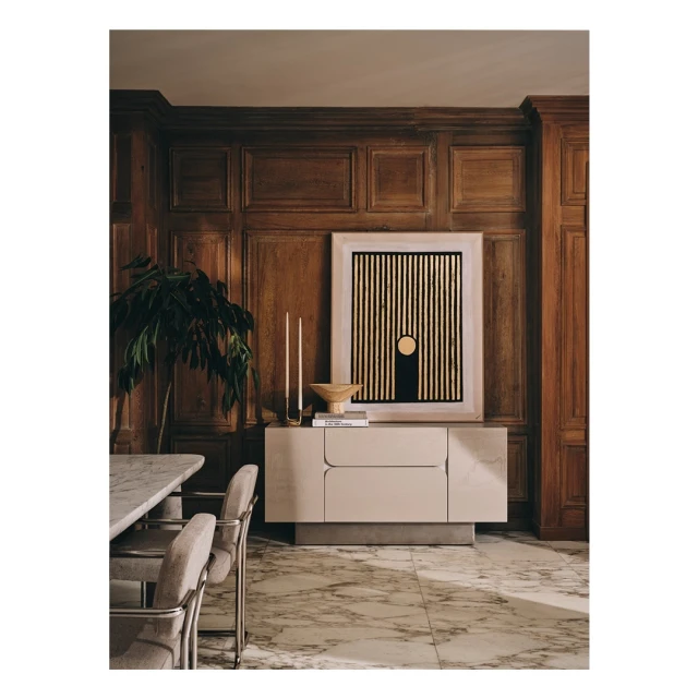 Living room interior featuring a modern sideboard with abstract art, marble floor, wooden wall paneling, and a dining table with chairs.