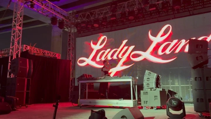 Live music performance with a DJ on stage, stage lighting, audio speakers, and 'Lady Lan' text display.