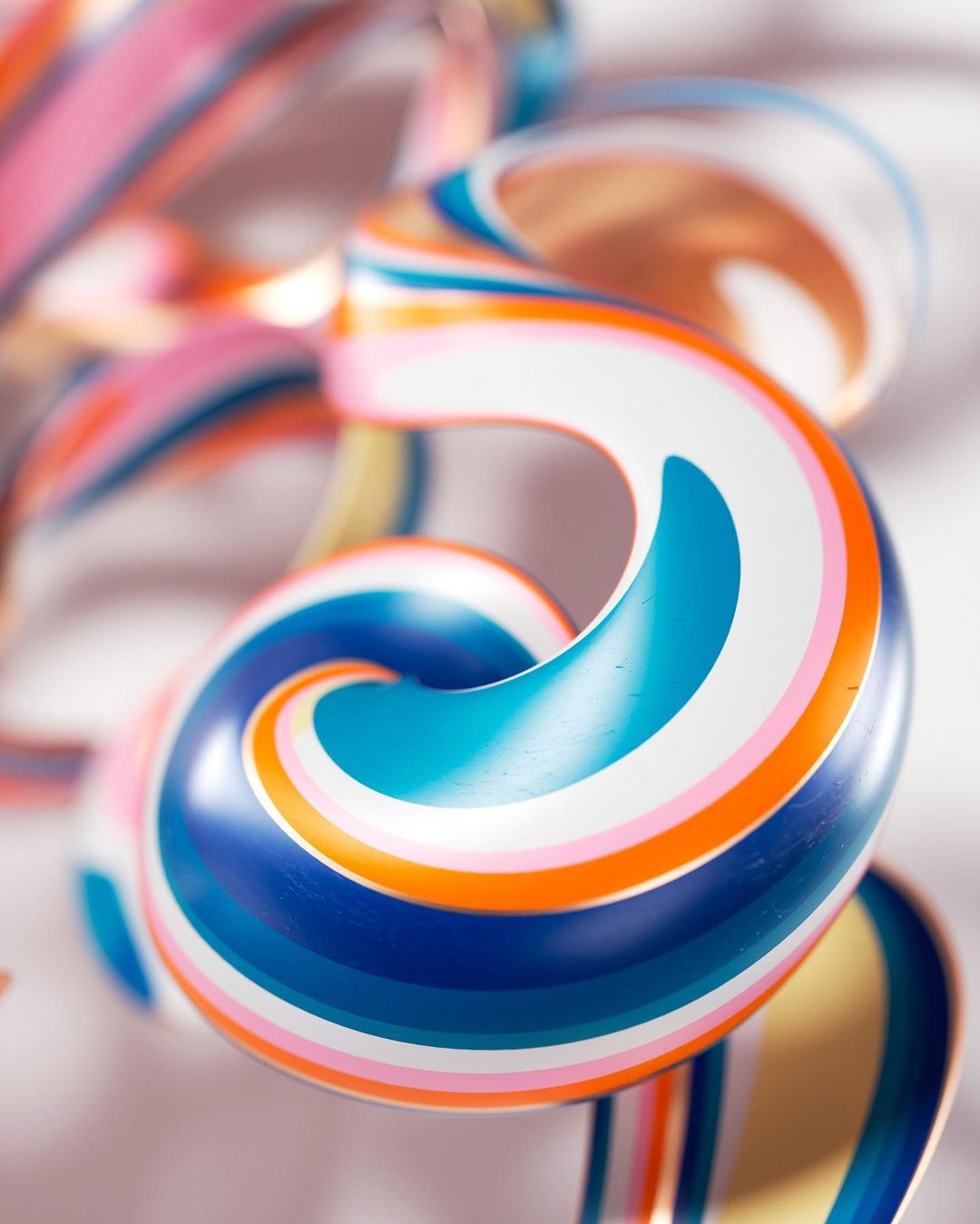 Abstract close-up of a multicolored striped, glossy looping form. Light and bright, with a white background. Modern abstract design.