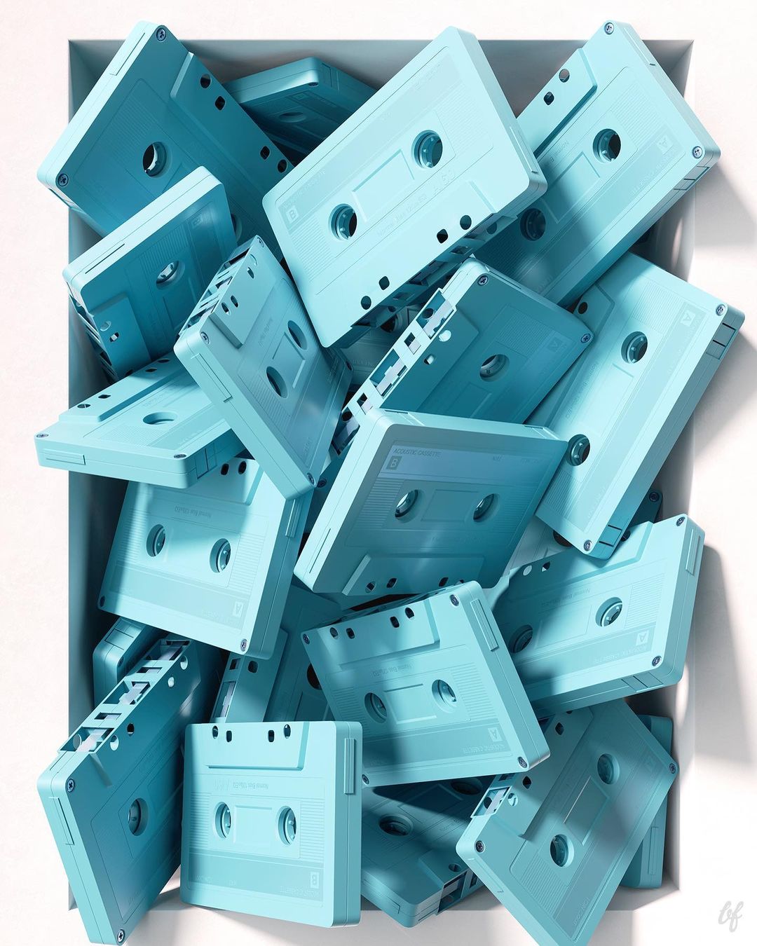 Overhead close-up of a collection of light blue audio cassettes arranged in a white box, casting a soft shadow in a studio.