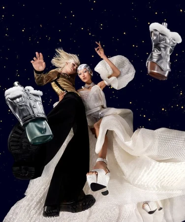 Two models wearing avant-garde fashion pose against a dark blue starry backdrop, showcasing futuristic styles and accessories. 