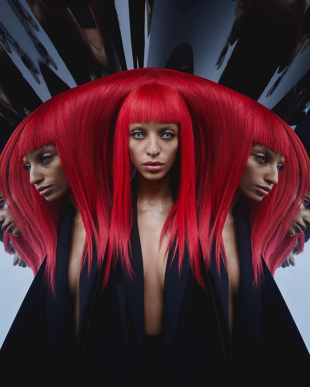 Portrait of a woman with vibrant red hair and a black blazer, captured through a kaleidoscopic mirror effect by photographer Ben Fourmi.