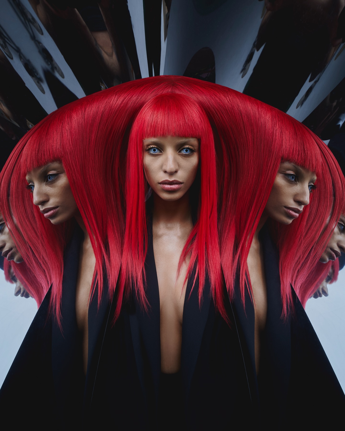 Close-up studio shot of an adult female with vibrant red hair, wearing a black jacket, and featuring a mirrored, multi-exposure effect.