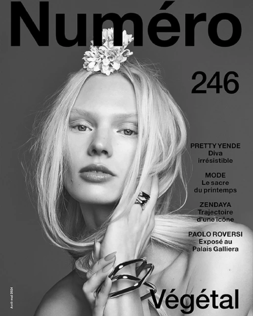 Black and white magazine cover featuring a blonde woman with a floral headpiece, jewelry, and a grey background. Text includes 'Numero'.
