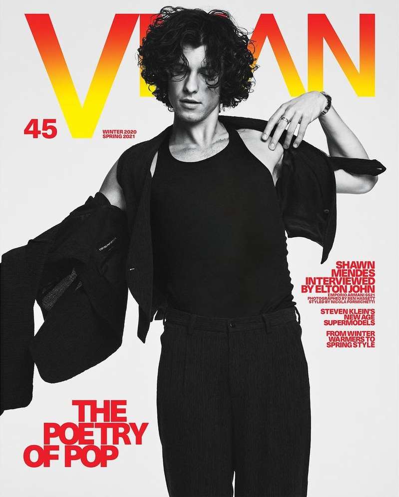 Magazine cover featuring Shawn Mendes in black tank top and jacket, with bold yellow and red typography on a neutral background.