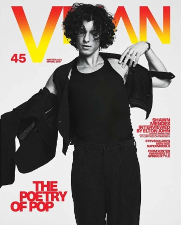Magazine cover featuring Shawn Mendes in black tank top and jacket, with bold yellow and red typography on a neutral background.