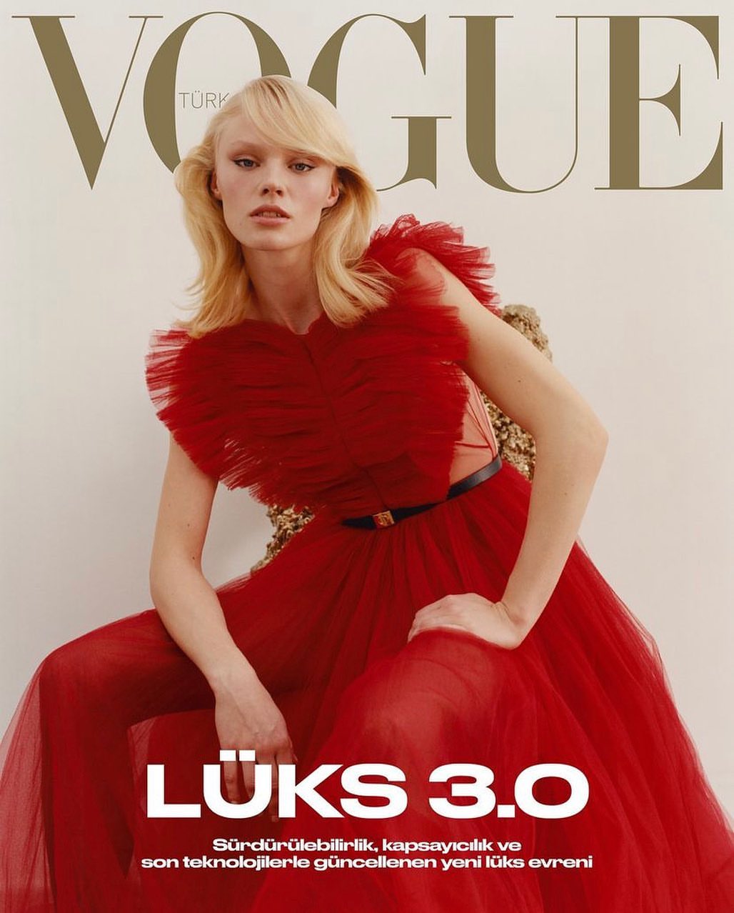 Vogue Turkey magazine cover featuring a model with blonde hair, wearing a red tulle dress, and seated on a gold textured chair.