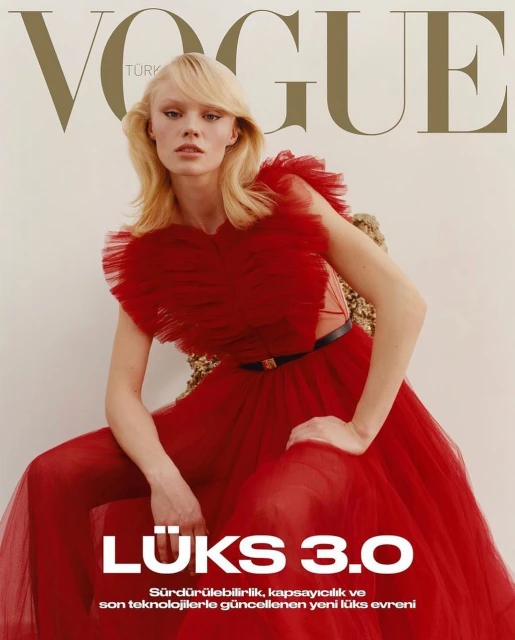 Vogue Turkey magazine cover featuring a model with blonde hair, wearing a red tulle dress, and seated on a gold textured chair.