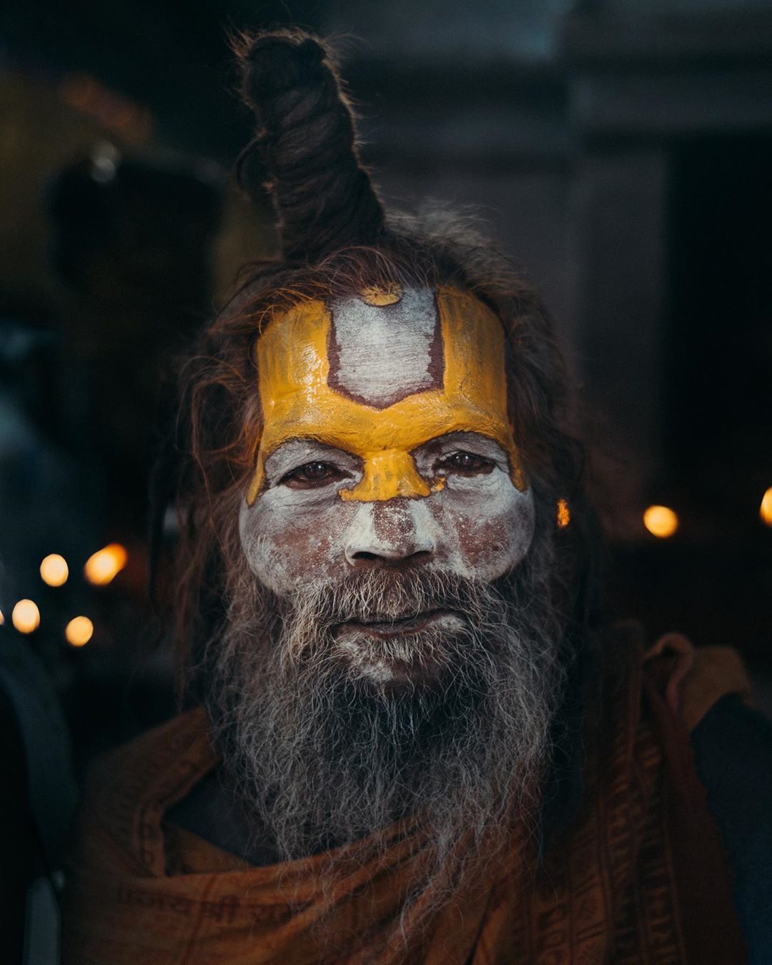 Portrait of an Indian Sadhu, a religious ascetic, with long beard and sacred markings on his face in a medium studio shot.