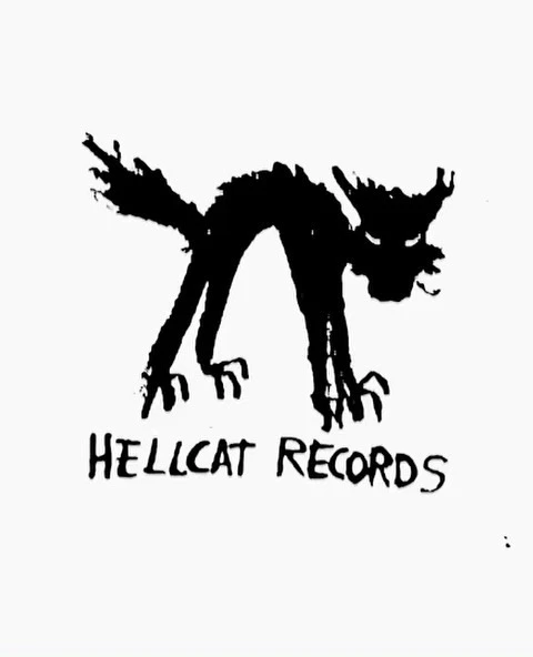 Black and white illustration of the Hellcat Records logo featuring a menacing cat figure with sharp claws and visible text.