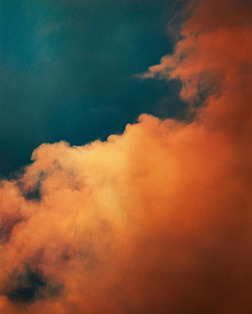 Abstract view of dark blue sky meeting orange clouds at the diagonal. Warm and cool tones create contrast in this skyscape.
