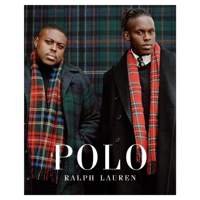 Two adult males stand indoors against a tartan backdrop, wearing dark overcoats and scarves in a fashion editorial by Polo Ralph Lauren.
