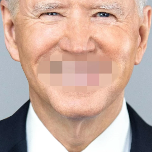 Close-up of a smiling adult with a blurred out mouth, wearing a dark suit jacket against a grey background.