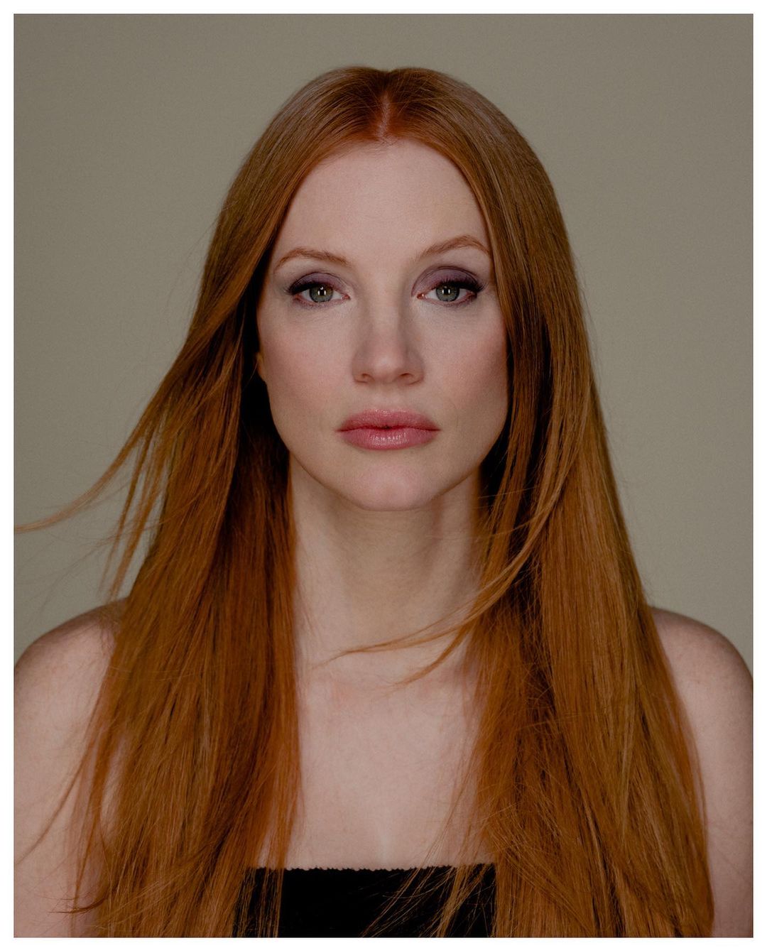 Close-up portrait of a red-haired adult woman with fair skin and natural makeup, captured in a photo studio setting.