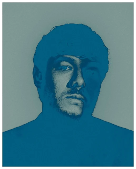 Monochromatic portrait of a man with short hair and stubble, rendered in shades of blue against a muted gray background.